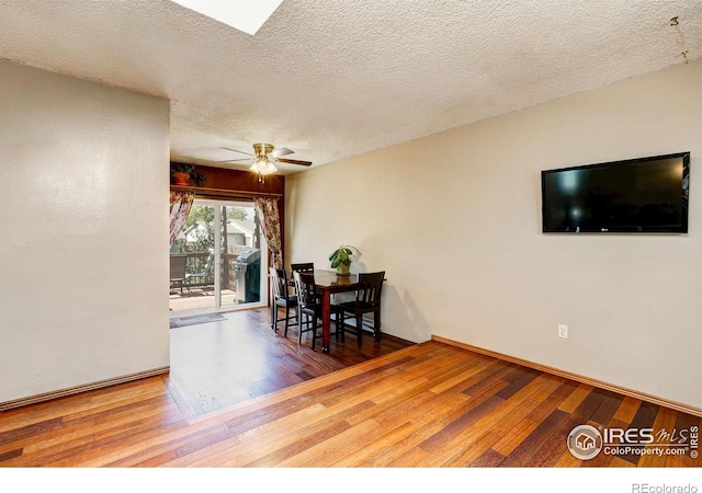 dining space with a textured ceiling, hardwood / wood-style flooring, and ceiling fan