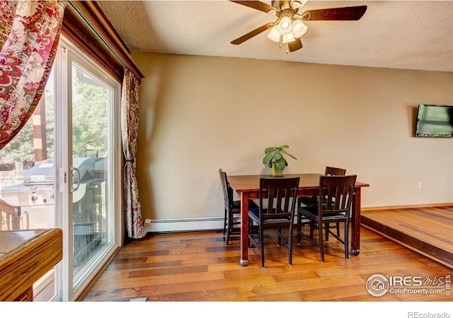 dining room featuring hardwood / wood-style floors, a textured ceiling, ceiling fan, and a baseboard heating unit