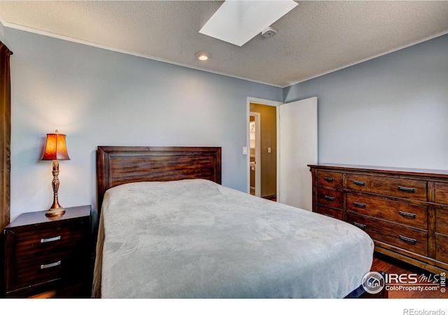 bedroom with a skylight and a textured ceiling