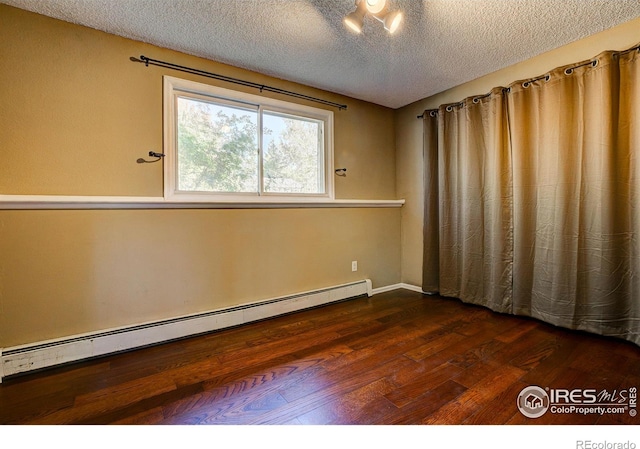 spare room with baseboard heating, dark hardwood / wood-style flooring, and a textured ceiling