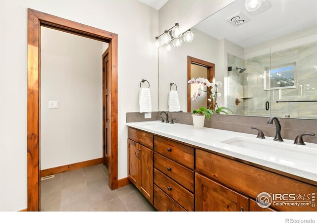 bathroom with a shower with door, tile patterned flooring, and vanity