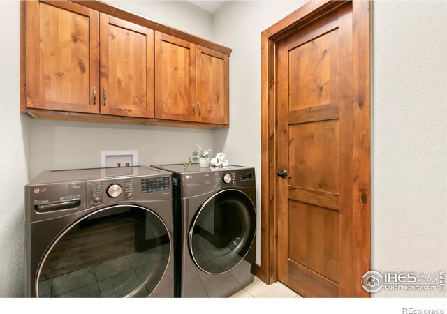 laundry room with light tile patterned flooring, cabinets, and separate washer and dryer