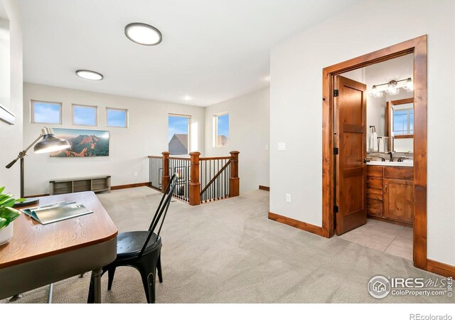 carpeted office with plenty of natural light and sink