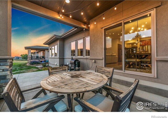 patio terrace at dusk featuring area for grilling