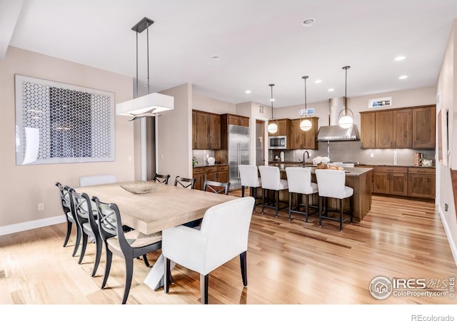 dining space featuring sink and light hardwood / wood-style flooring