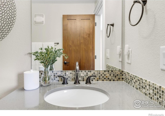 bathroom featuring backsplash and sink