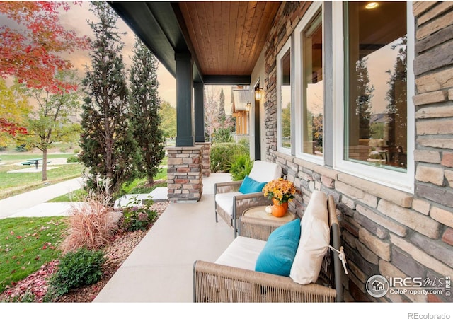 patio terrace at dusk featuring a porch