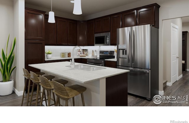 410 High Point Dr Unit 104, Longmont, CO 80504 - kitchen featuring sink, a center island with sink, appliances with stainless steel finishes, dark hardwood / wood-style floors, and decorative backsplash