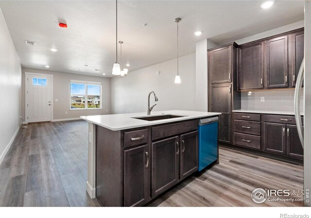 410 High Point Dr Unit 104, Longmont, CO 80504 - kitchen featuring sink, dishwasher, decorative backsplash, a center island with sink, and decorative light fixtures