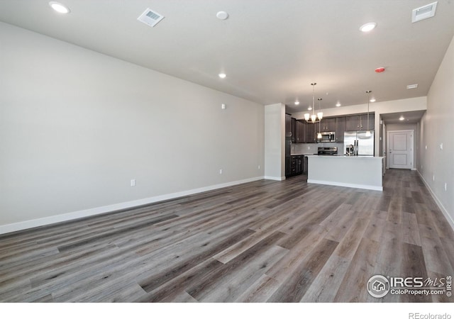 410 High Point Dr Unit 104, Longmont, CO 80504 - unfurnished living room featuring dark hardwood / wood-style flooring and a chandelier