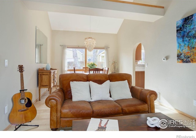 living room with light hardwood / wood-style flooring, vaulted ceiling, and a notable chandelier