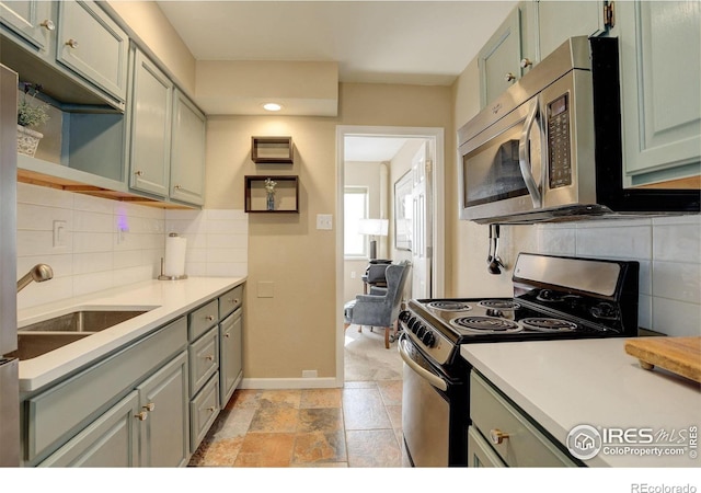 kitchen featuring tasteful backsplash, sink, stainless steel appliances, and green cabinetry