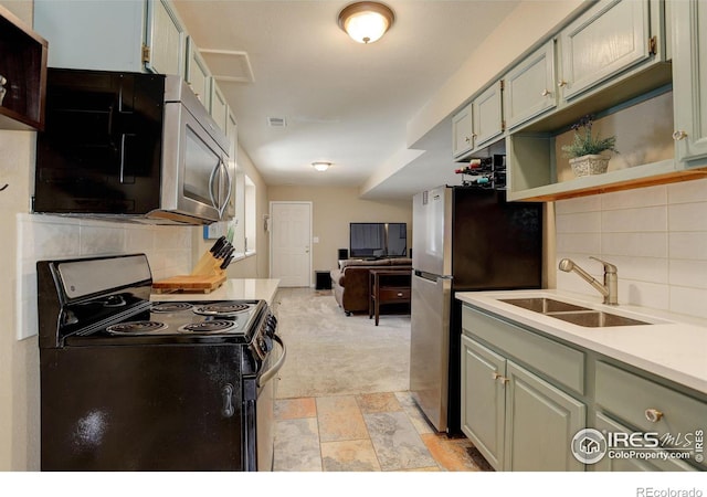 kitchen with sink, appliances with stainless steel finishes, and tasteful backsplash