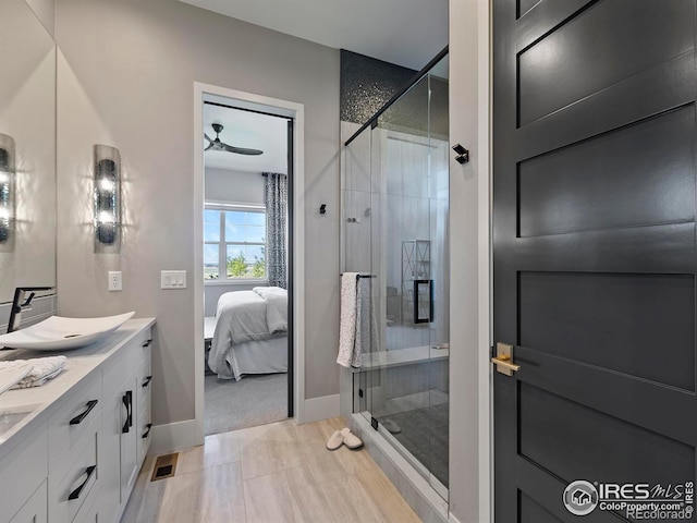 bathroom with vanity, an enclosed shower, and ceiling fan