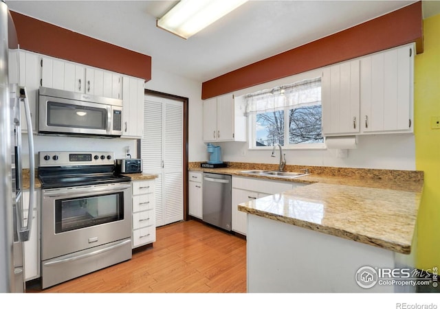 kitchen featuring white cabinets, sink, light wood-type flooring, and stainless steel appliances