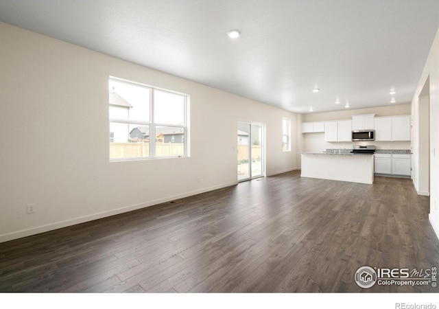 unfurnished living room featuring dark wood-type flooring