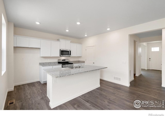 kitchen with white cabinetry, sink, light stone counters, a kitchen island with sink, and appliances with stainless steel finishes