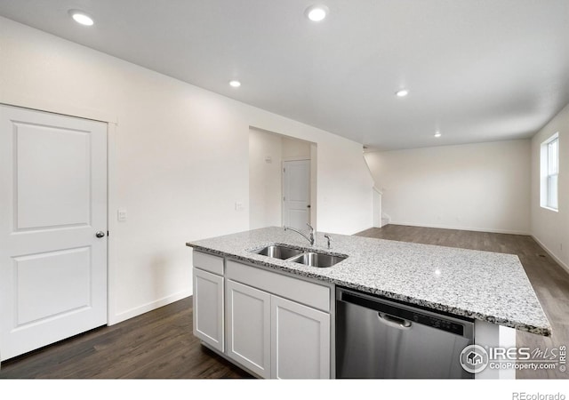 kitchen featuring light stone countertops, sink, dishwasher, white cabinetry, and an island with sink