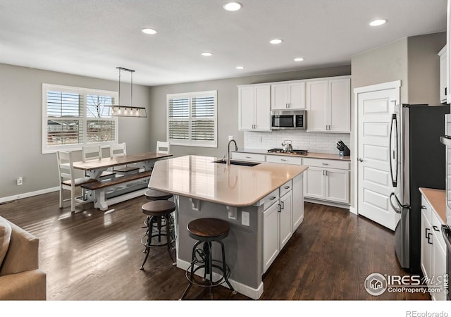 kitchen featuring white cabinets, pendant lighting, and appliances with stainless steel finishes