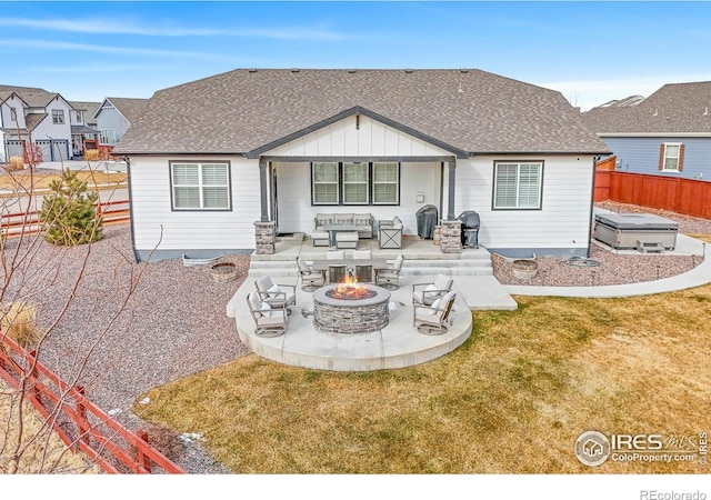 rear view of house featuring a lawn, a fire pit, a jacuzzi, and a patio