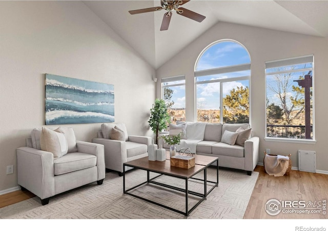 living room featuring ceiling fan, lofted ceiling, and light wood-type flooring