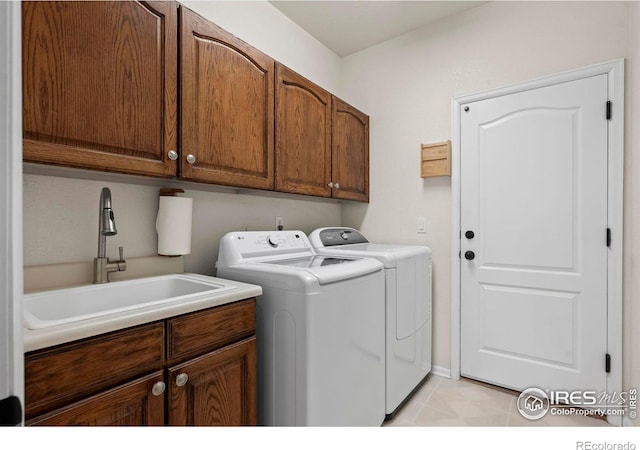 laundry room featuring cabinets, washing machine and clothes dryer, and sink