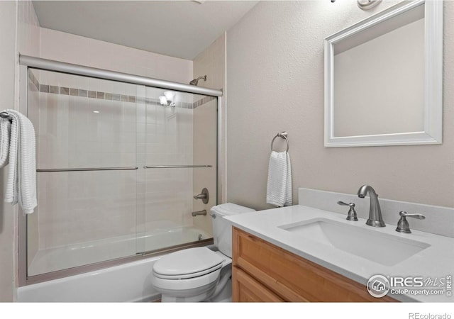 full bathroom featuring shower / bath combination with glass door, vanity, and toilet