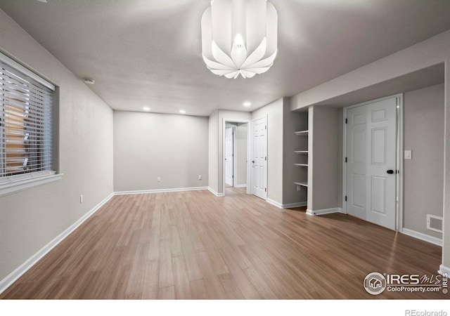 interior space featuring hardwood / wood-style flooring and built in shelves