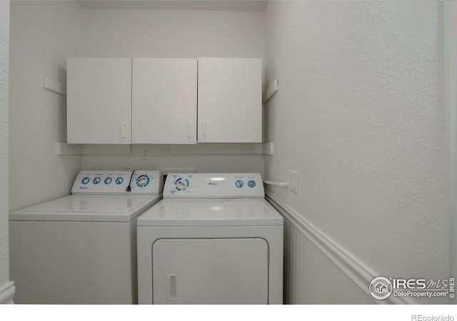 clothes washing area featuring cabinets and independent washer and dryer