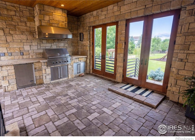 exterior space featuring wooden ceiling, wall chimney range hood, refrigerator, and french doors