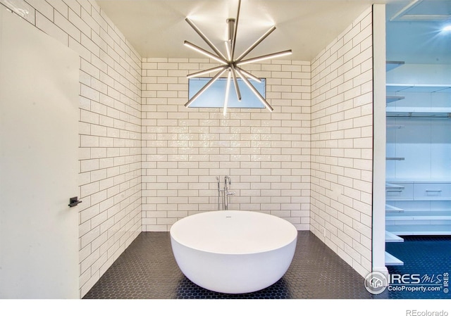 bathroom featuring an inviting chandelier and a washtub