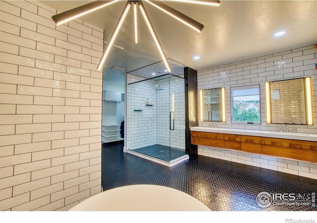 bathroom with a shower with shower door and vanity