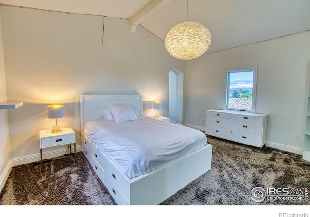 bedroom with dark carpet and lofted ceiling with beams