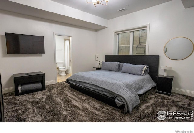 bedroom with ensuite bathroom, carpet, and a notable chandelier