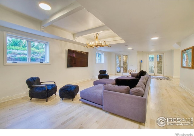 living room with light hardwood / wood-style floors, french doors, and a notable chandelier