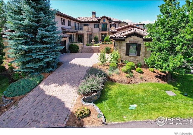 mediterranean / spanish-style home with a garage and a front lawn