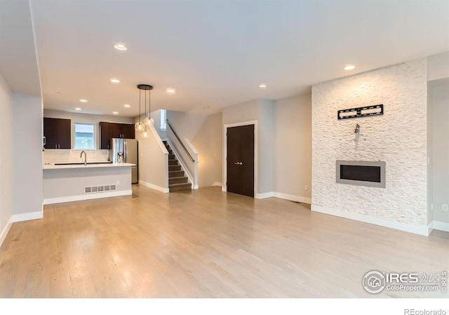 unfurnished living room with a fireplace and light wood-type flooring