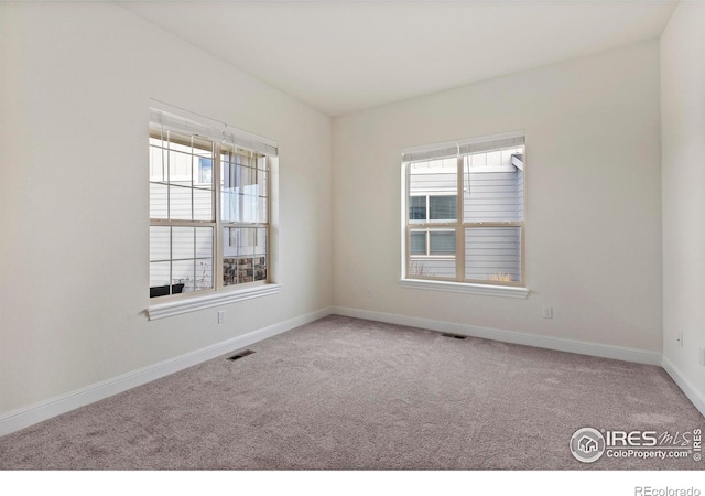 carpeted spare room with a healthy amount of sunlight