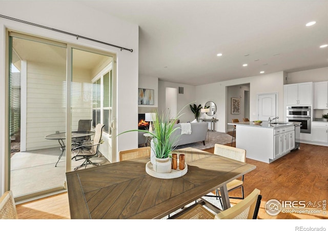 dining space with light hardwood / wood-style flooring and sink