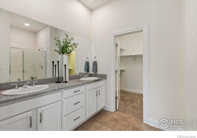 bathroom with vanity and a shower with door