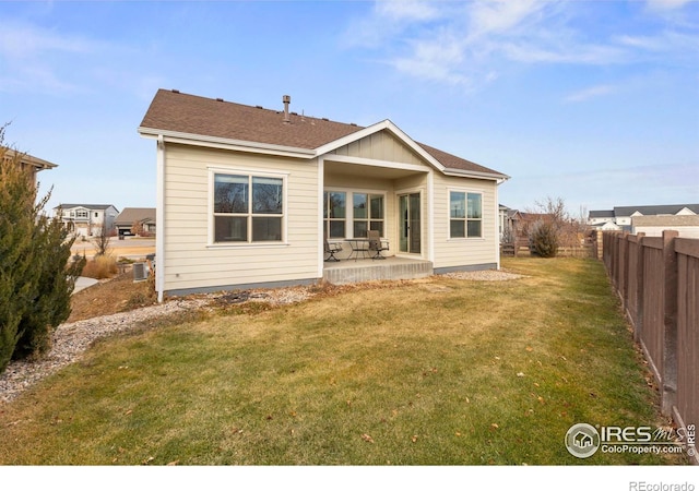 rear view of house featuring a lawn, central air condition unit, and a patio