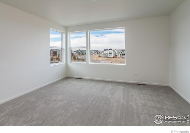 carpeted spare room with baseboards