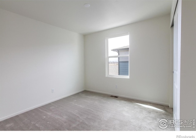 unfurnished bedroom with carpet, visible vents, and baseboards