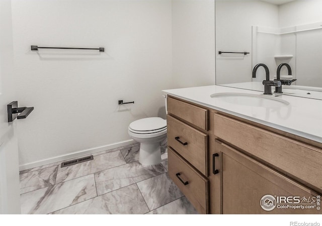 bathroom featuring toilet, visible vents, vanity, baseboards, and marble finish floor