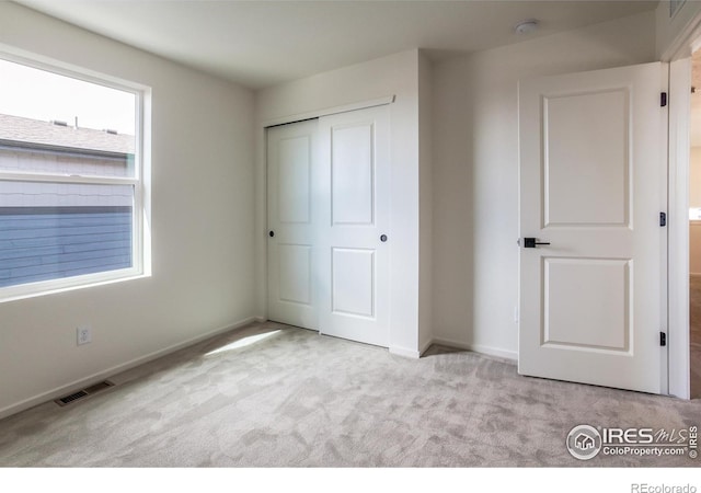 unfurnished bedroom featuring a closet, visible vents, baseboards, and carpet flooring