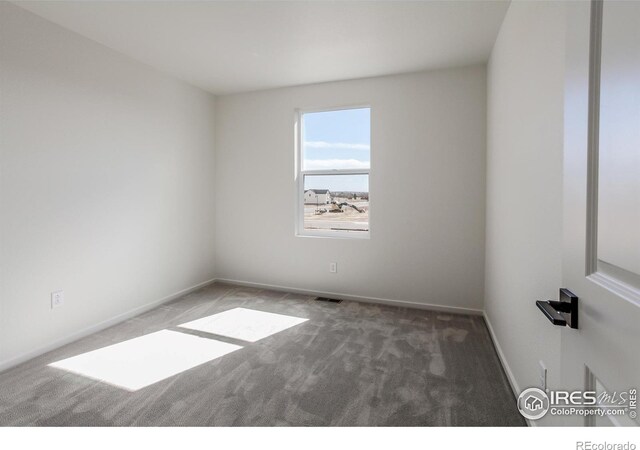 spare room featuring baseboards, visible vents, and carpet flooring