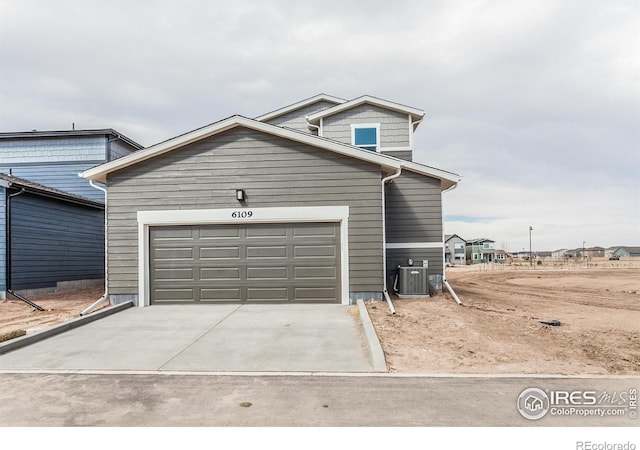 view of front of house featuring driveway, a garage, and central AC unit