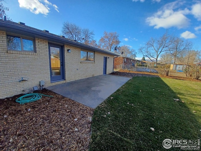 rear view of property with a patio and a lawn