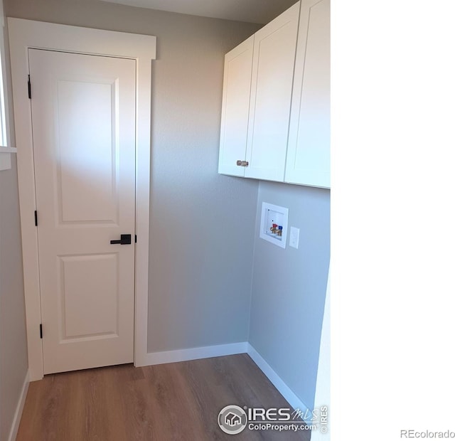 laundry room with hookup for a washing machine, cabinets, and dark hardwood / wood-style flooring