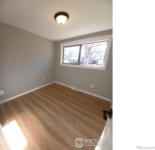 unfurnished room with hardwood / wood-style flooring